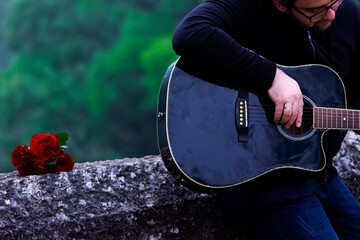 Romantic scene of man playing guitar leaning against the bridge
