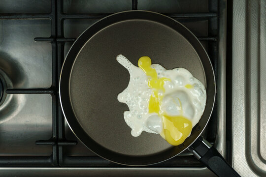 The egg broke unsuccessfully in the frying pan. Ugly scrambled eggs.