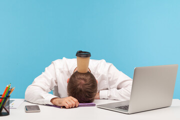 Overworked exhausted man office worker lying on table, paper coffee cup standing on his head, lack...