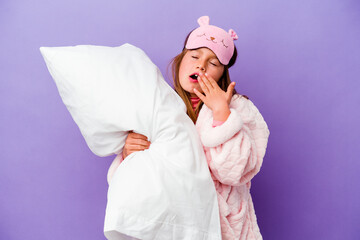 Little girl embracing a pillow happy isolated on purple background