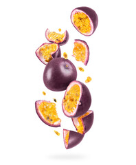 Whole and sliced ripe passion fruit in the air on a white background
