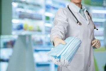 Medical professional holds out a stack of masks .