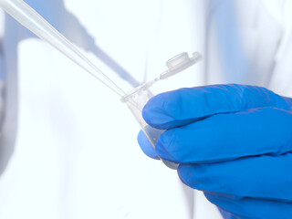 Laboratory researcher or nurse pipets patient sample into a test tube. Genetic engineering or...