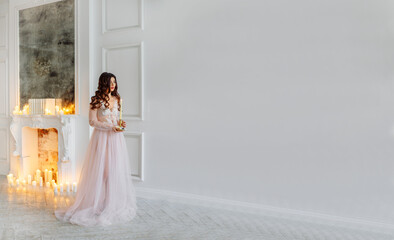A bride in a white interior in a beautiful boudoir dress.