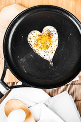 fried eggs in the shape of the heart in a pan. Flat lay top-down.