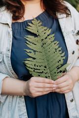girl holding a fern leaf in her hands Spring nature green plants
