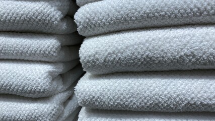 Towels. A stack of folded white cotton terry towels in close-up. Fabric Texture