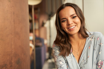 Beautiful young happy woman smiling on the home background with copy space