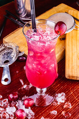 Cranberry cocktail with ice and berries on wooden background