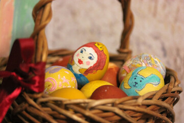 Easter wooden wicker basket filled with colorful eggs on the eve of Easter. Warm background. Horizontal photo.