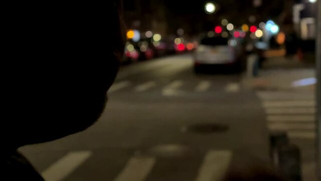 burning joint - man smoking marijuana cigarette in street at night in New York City NYC
