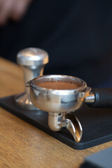 coffee grind temped in espresso holder on table, closeup