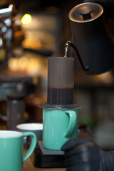 pouring water from kettle into aeropress, coffee brewing process closeup