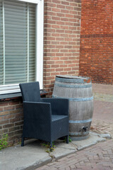 Chair and wooden barrel in front of a house