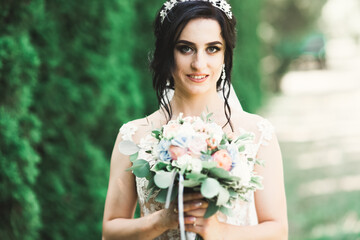 Portrait of stunning bride with long hair posing with great bouquet