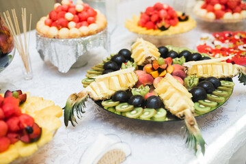 Delicious and tasty dessert table with cupcakes shots at reception closeup