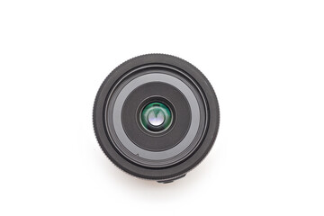 A small thin black 24 mm lens for a digital SLR camera without a name lying on a white background...