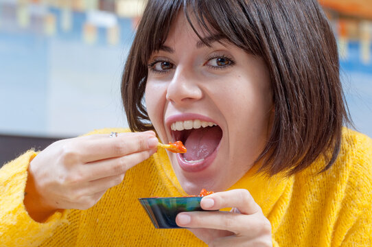 Primo piano di una bella ragazza allegra che mangia cibo messicano