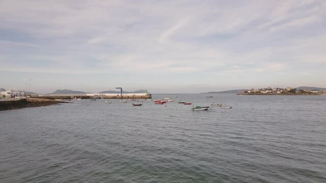 Zoom in de un puerto con barcos peque&ntilde;os o barcazas y un espig&oacute;n.