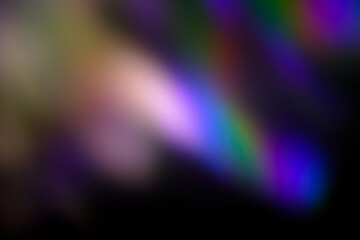 Blur colorful warm rainbow light leaks on black background with dust texture. Defocused abstract damaged scratched retro film analog effect for using over photos as overlay or screen filter