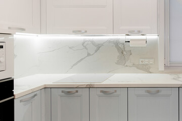 Fototapeta na wymiar Beautiful white and grey kitchen with silver furniture.