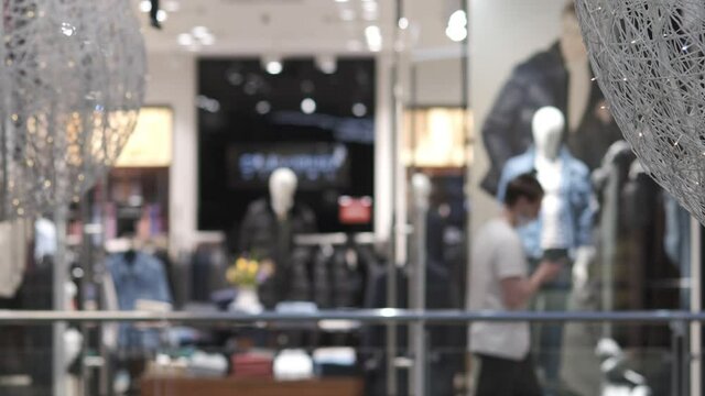 Showcase of a clothing store. Blurred image of people in a shopping mall