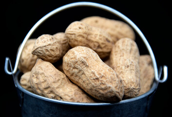 Peanuts in a miniature bucket close up