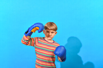 Fototapeta na wymiar Boy in blue boxing gloves boxing