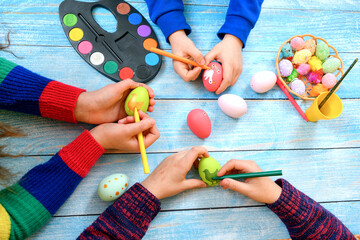 Children draw various drawings on Easter eggs for the Easter holiday.