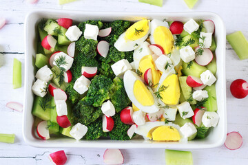 Spring salad with broccoli, cucumber, egg, radish and feta cheese