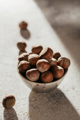 Pile of hazelnuts filbert in a bowl on a white background