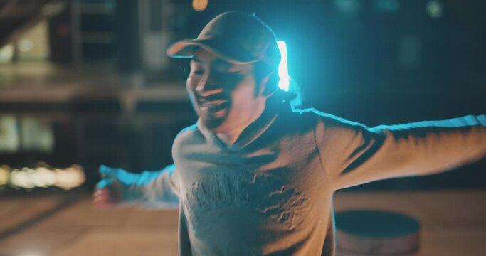 Cool backlit street dancer performing in city street at night