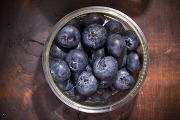 blueberries in a bowl on wooden table
