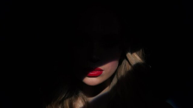 Beautiful model with bright makeup and red lips. Portrait of a girl close-up on a blue background.