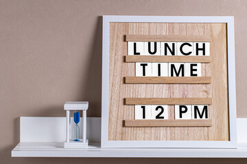 a wooden board with the words lunch time inserted.