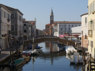 Fototapeta na wymiar Chioggia, Vena Canal with colorful ancient buildings on both sides and crossed by ancient bridges