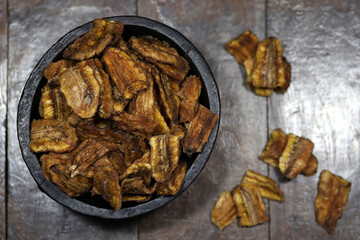 dried organic banana in a wooden bowl on wooden background