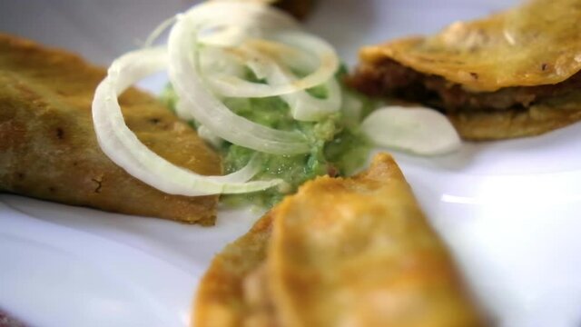 Mexican basket tacos and onion slices on white plate