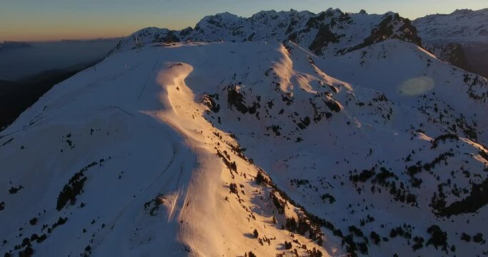 Mountain landscape at Chamrousse, France in the snow capped Alps during sunrise, Aerial orbit right reveal shot
