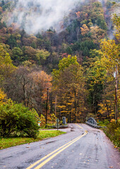 Obraz premium road trip on open road and highway traversing vibrant autumn woods