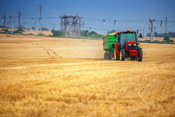 Obraz premium Tractor with trailer during harvest