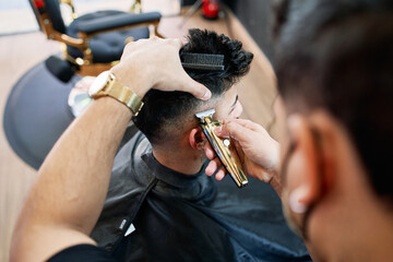 young black-haired boy getting his hair cut in a barber shop