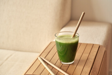 A glass of green juice with a bamboo straw - zero waste concept