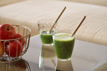 Two glasses of green juice with bamboo straws - zero-waste concept