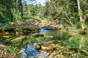 Naklejka na ściany i meble Cuba. Trinidad. Reserve Topes de Collantes. Guanayar Park. A mountain small rivulet flows into the lake