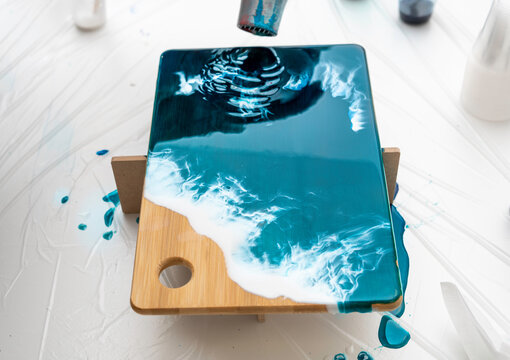 serving board, decorated with epoxy resin, imitation of the sea. Hair dryer to direct the air flow to spread the drawing on the board