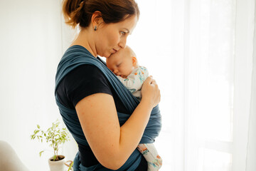Attachment parenting concept. Young mother with baby in sling