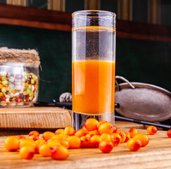 Сocktail with sea buckthorn on a wooden table