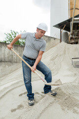 man takes a shovel of sand