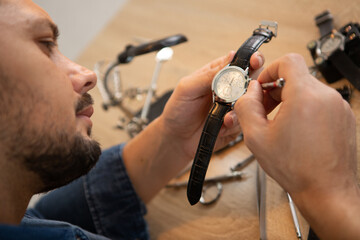 man fixes watch at chengdus city downtown